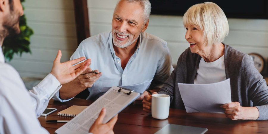 happy-aged-couple-consulting-with-insurance-agent-RKPKLHL.jpg